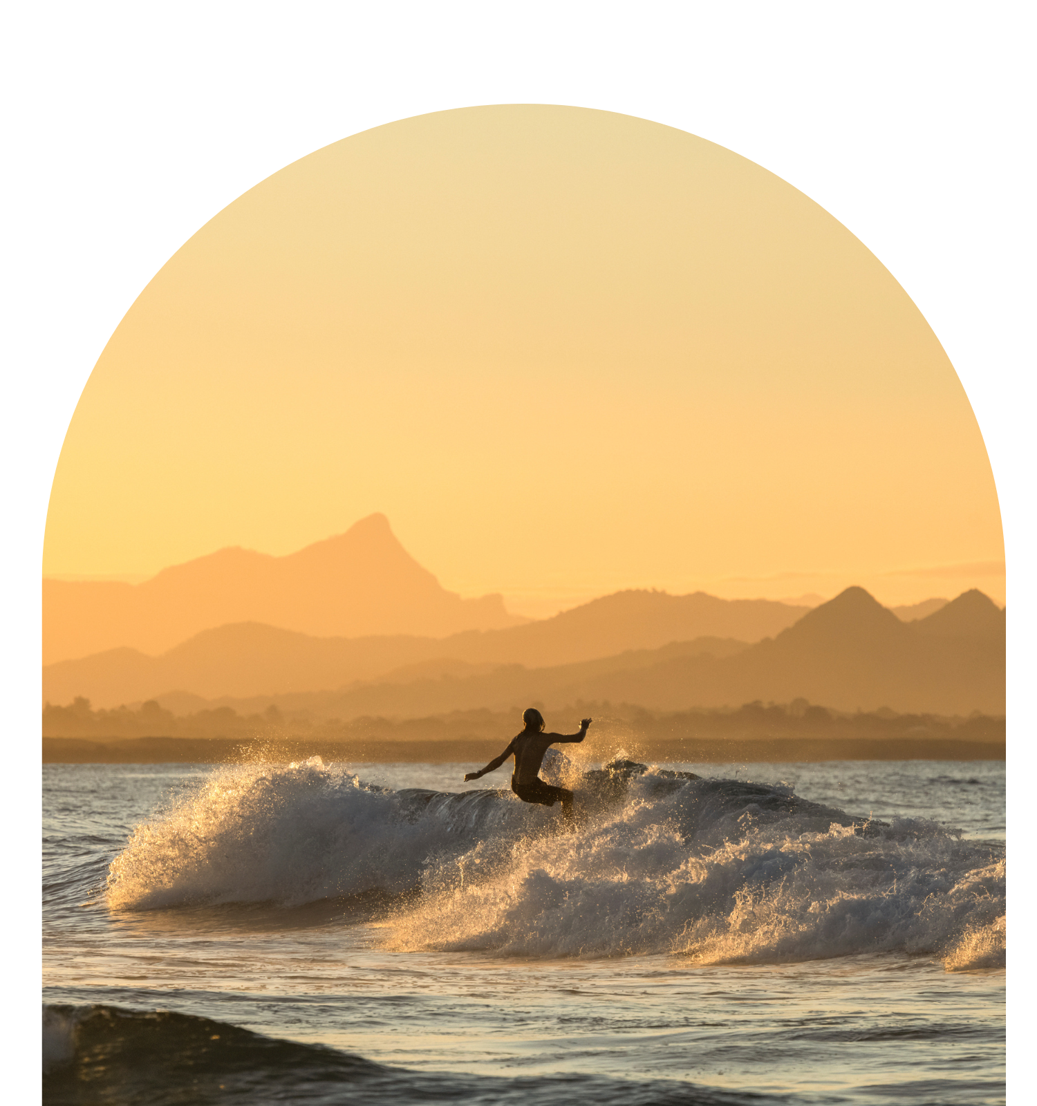 person on a wave surfing at sunset